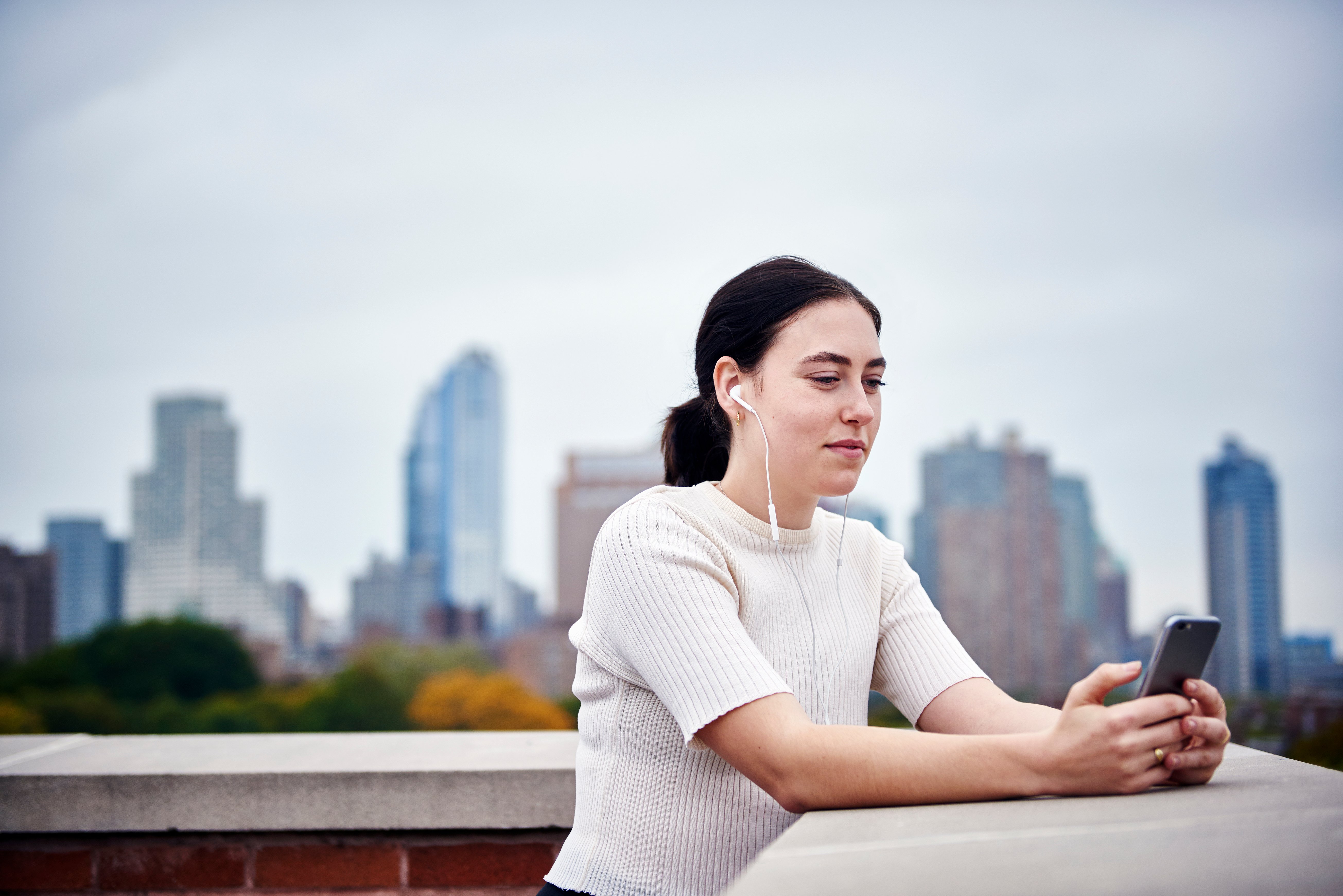 a-young-woman-standing-on-a-rooftop-looking-at-a-c-2023-11-27-05-04-41-utc