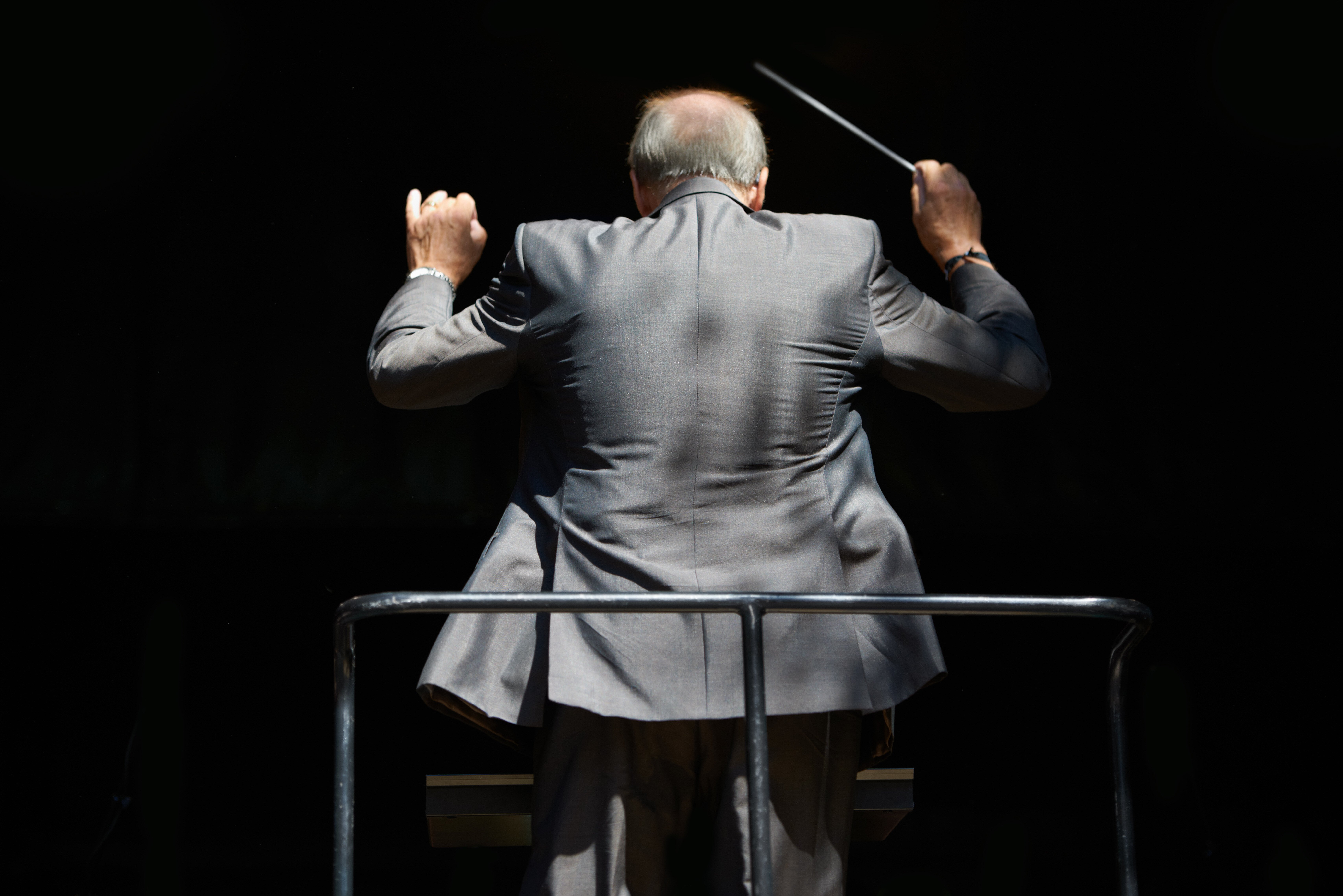 guiding-the-music-cropped-rear-view-of-an-orchest-2023-11-27-05-21-46-utc